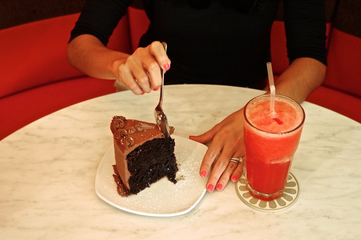 Woman eating a chocolate cake.